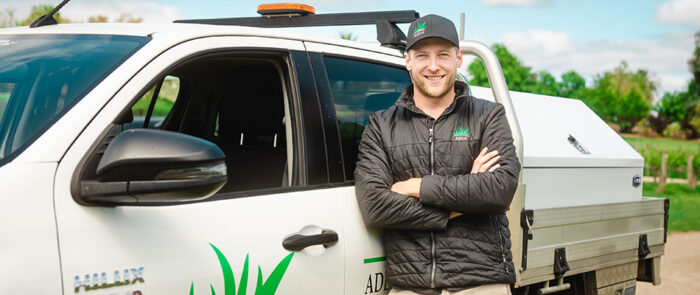 SAYES graduate, Luke Timmins, leaning against his work vehicle. 