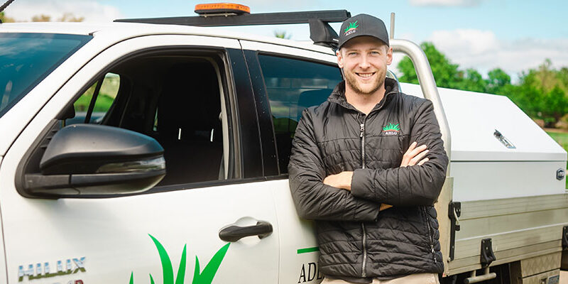 SAYES graduate, Luke Timmins, leaning against his work vehicle.