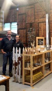 Matt & Nat standing in chook nook with rustic displays of chicken accessories.