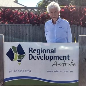 Richard Scollin standing next to sign that reads Regional Development Australia.