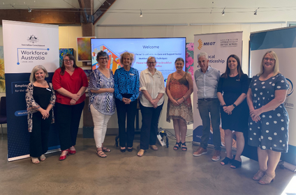 Attendees of Survive & Thrive breakfast standing in front of industry signage.