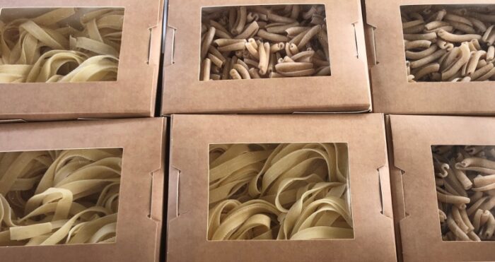Fresh handmade pasta in cardboard display boxes.