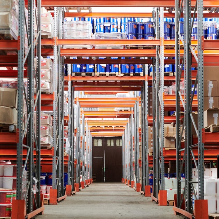 Warehouse with rows of tall shelves packed with different products.